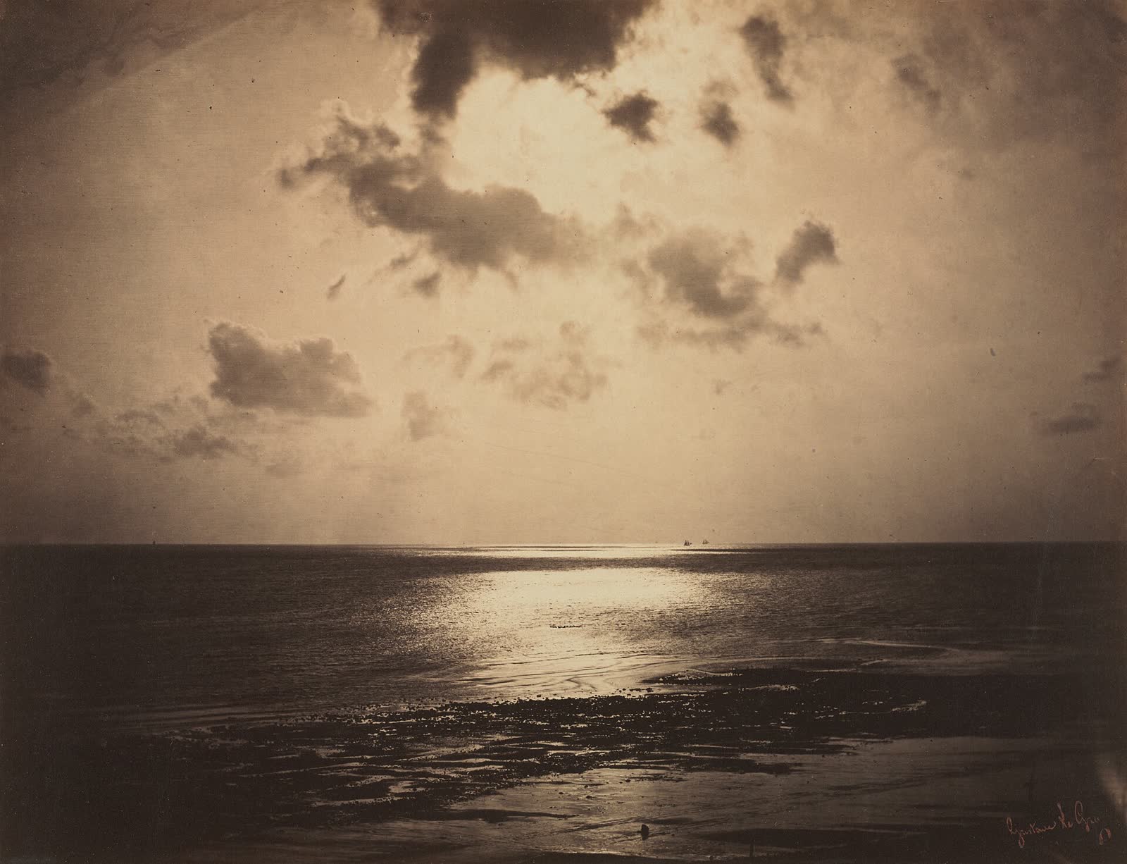 Fotografia antiga em tom sépia do sol refletido no mar sob nuvens